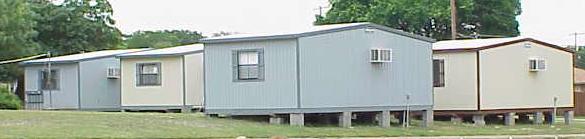 Storage buildings with air conditioners being used as classrooms.